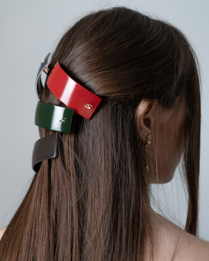 Person with colorful hair clips in their hair against a plain background